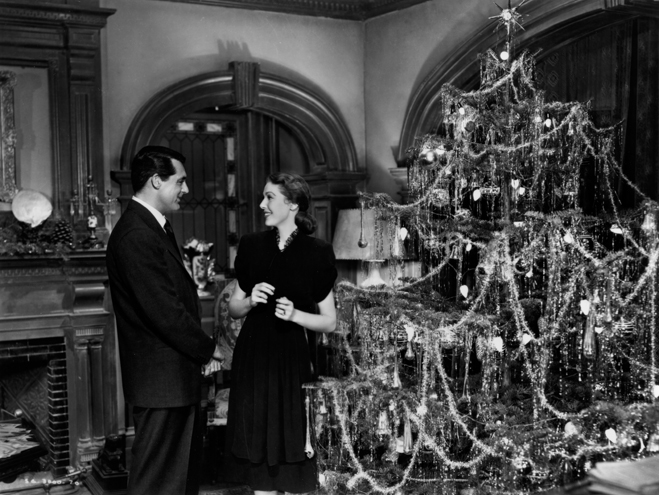 Cary Grant and Loretta Young standing next to a Christmas tree